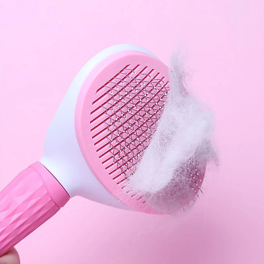 Pink pet grooming brush with collected fur on a pink background
